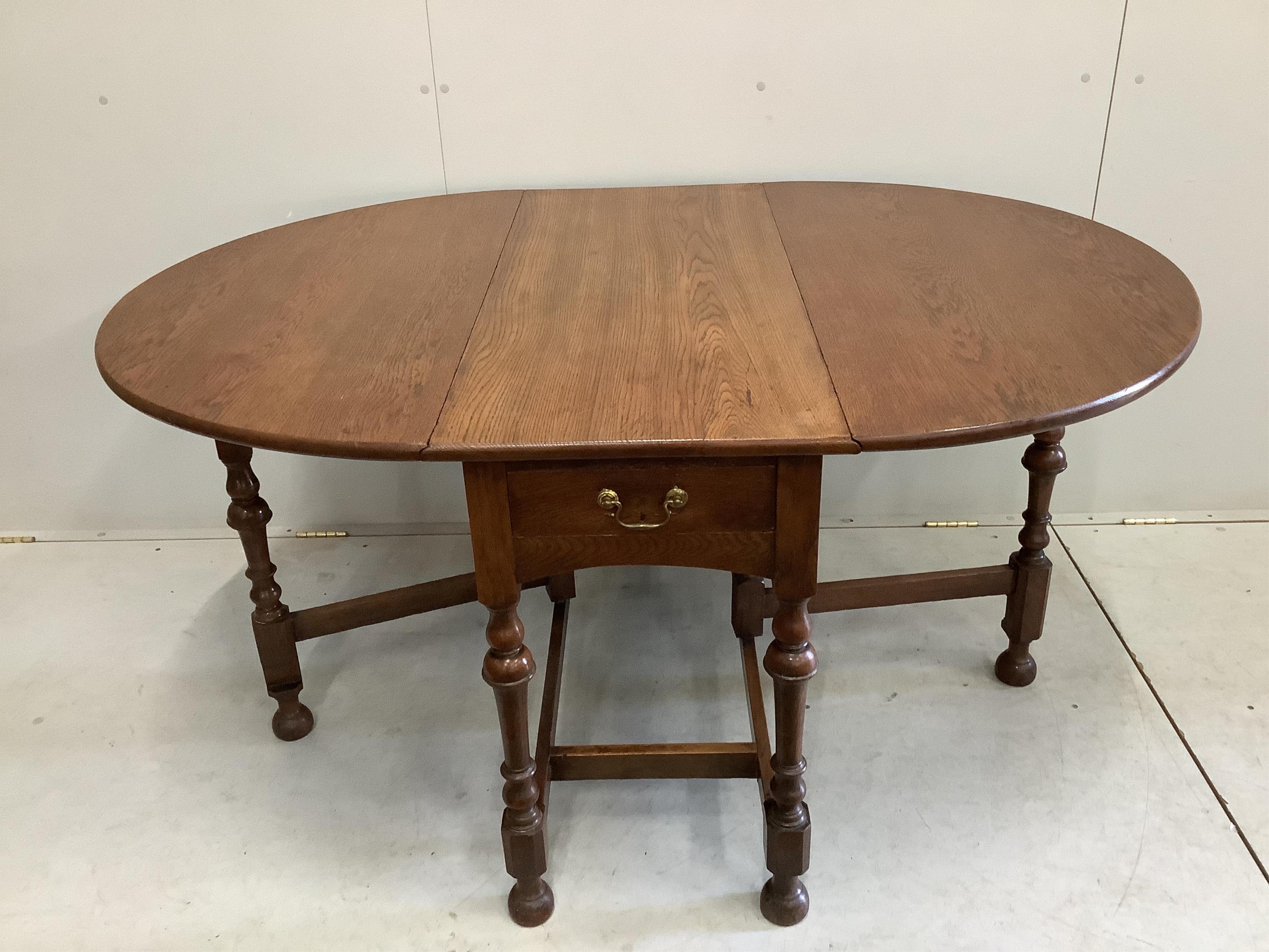 An early 20th century oak gateleg dining table, width 107cm, depth 47cm, height 74cm. Condition - fair to good